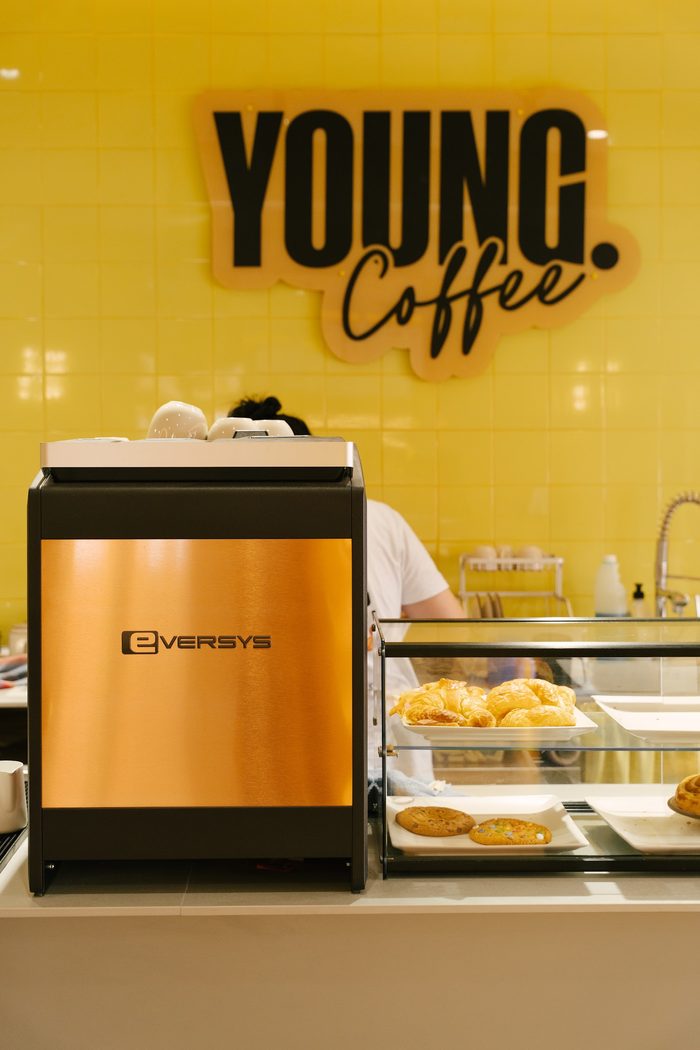 YOUNG Coffee painted down a wall in the brand yellow