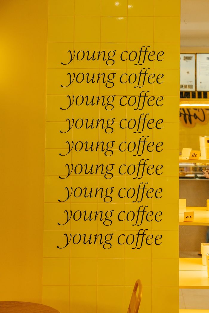 Young Coffee written down a wall of yellow tiles
